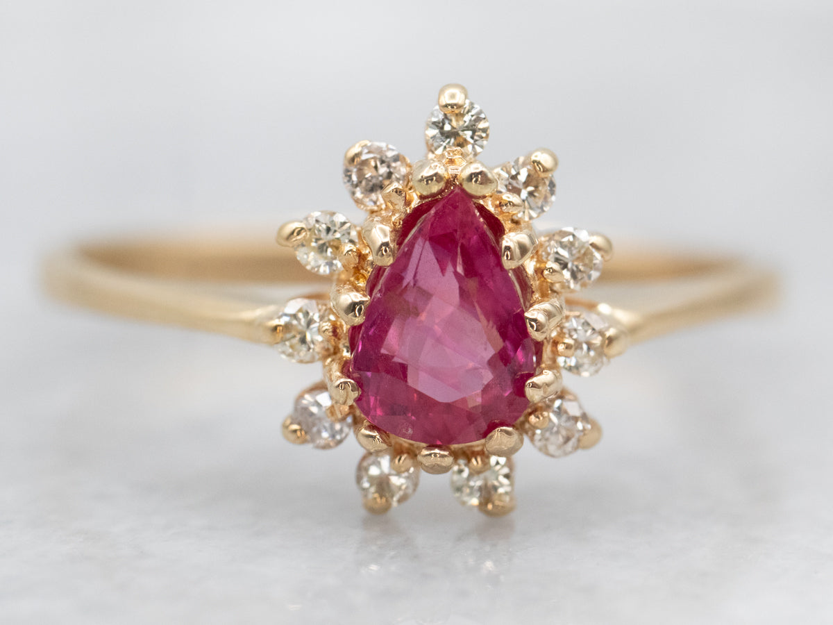 Lujoso anillo de oro amarillo con zafiro rosa de talla pera y halo de diamantes