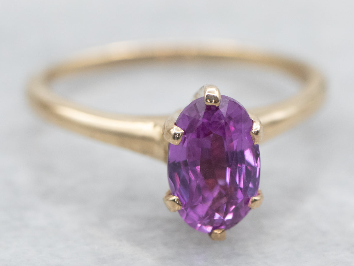 Anillo solitario de zafiro rosa de talla ovalada en oro amarillo