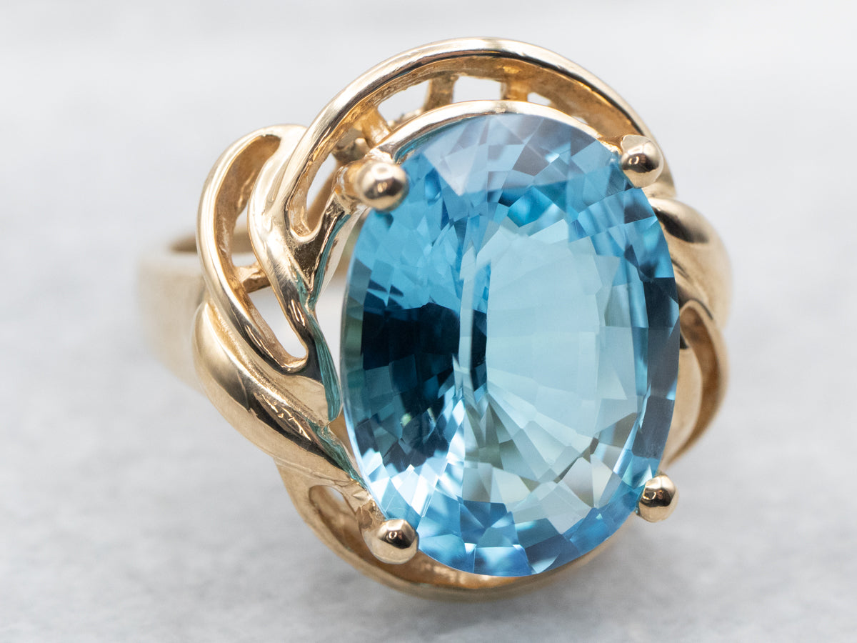 Anillo de cóctel de oro amarillo con topacio azul llamativo