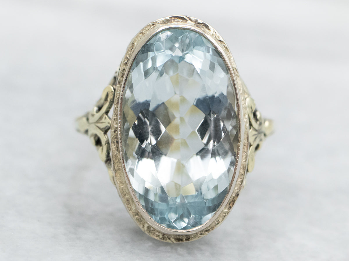 Anillo con solitario de topacio azul de talla ovalada en oro blanco y verde de dos tonos