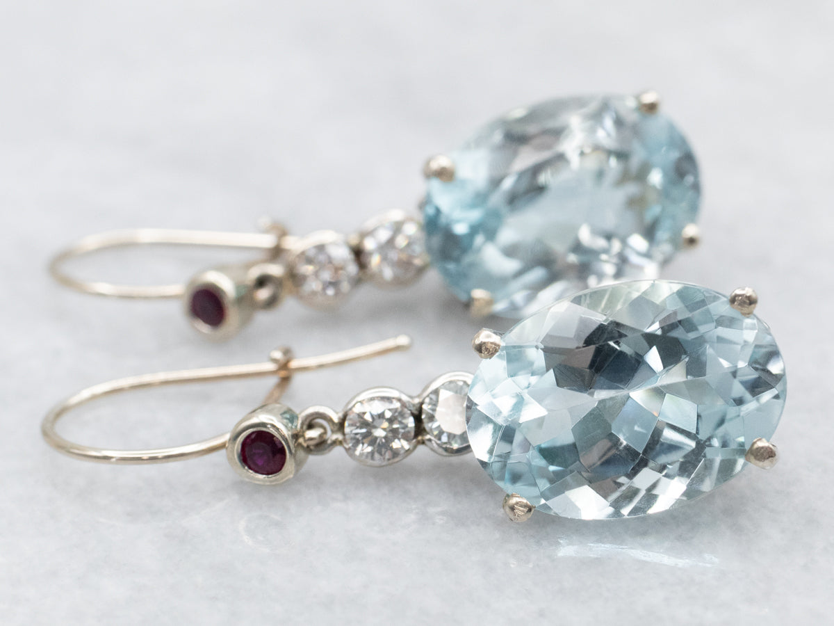 Aretes colgantes con topacio azul, diamantes y rubíes