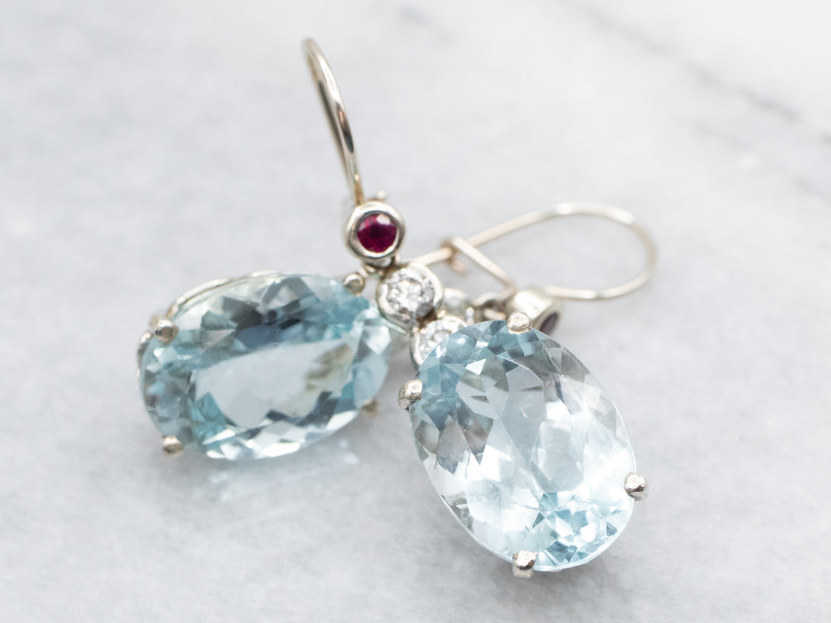 Aretes colgantes con topacio azul, diamantes y rubíes