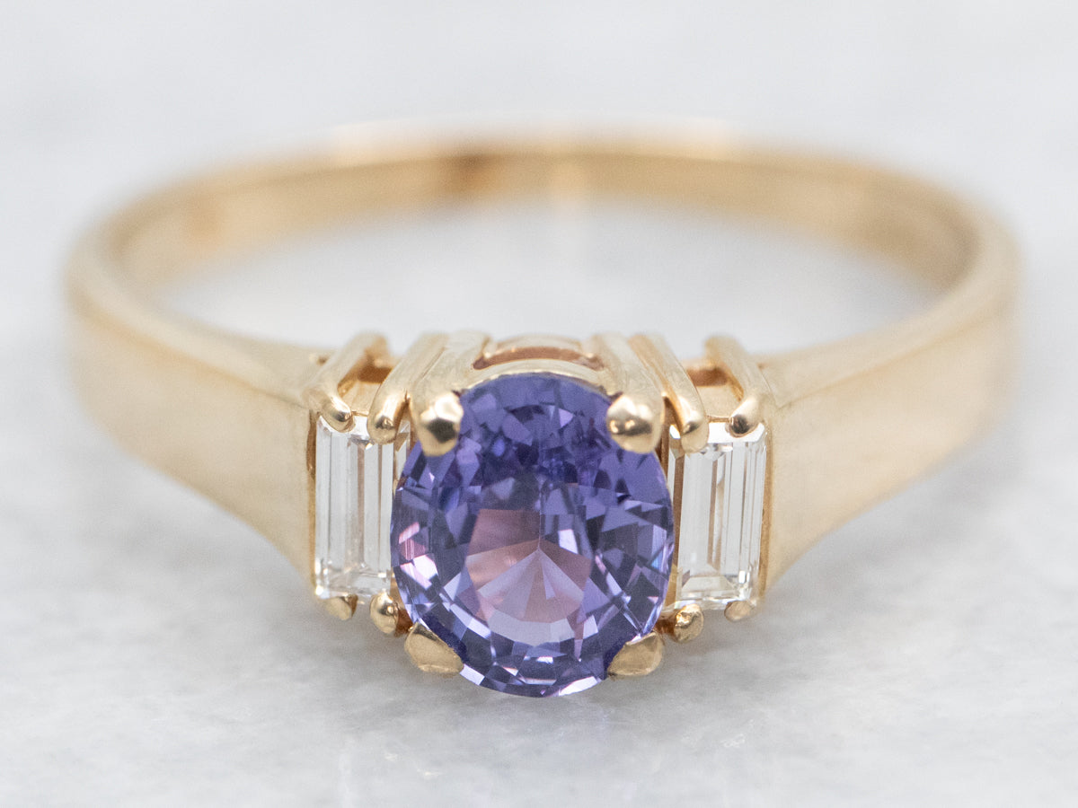 Anillo de oro amarillo con zafiro morado y detalles de diamantes