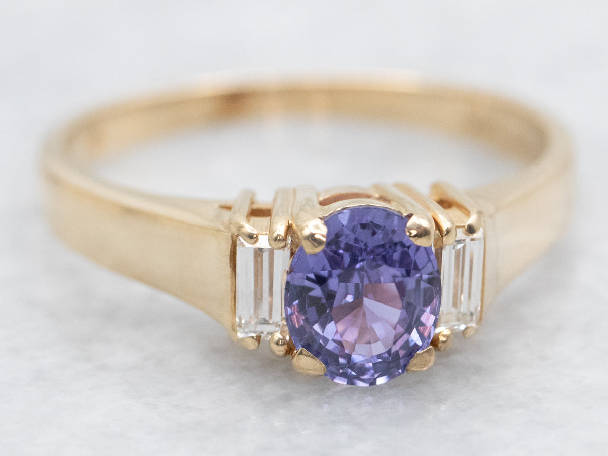 Anillo de oro amarillo con zafiro morado y detalles de diamantes