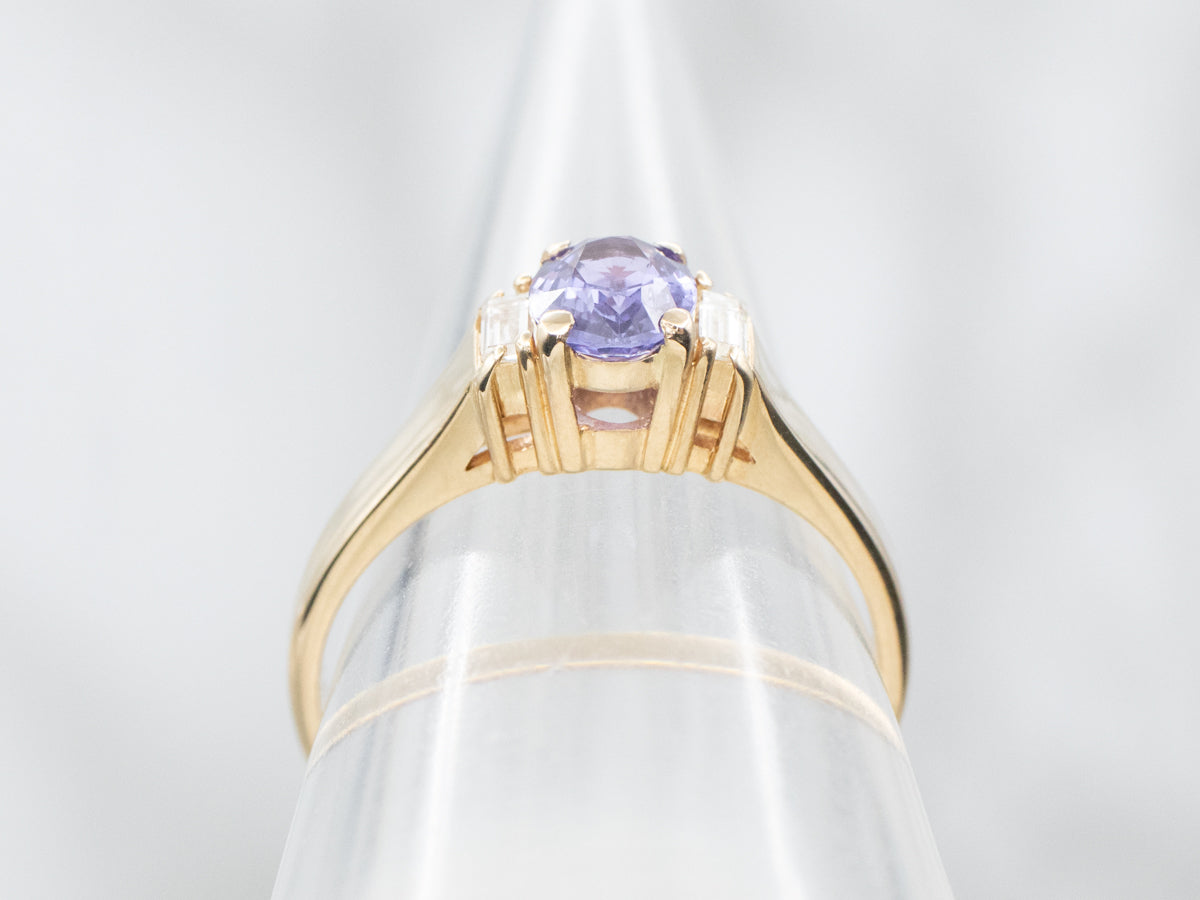 Anillo de oro amarillo con zafiro morado y detalles de diamantes