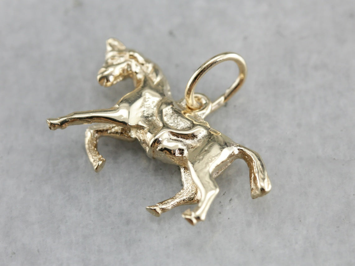 Charm dorado de caballo al galope vintage